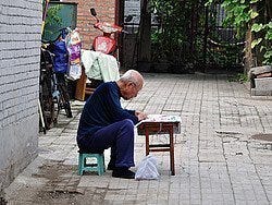 Leyendo el periódico en una sillita