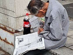 Leyendo el periódico en la calle