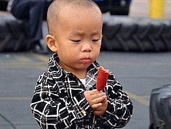 Niño degustando una salchicha
