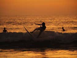 Surfistas en la playa de Kuta al atardecer