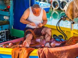 Pescador maltés arreglando su red